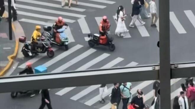 上海市中心路口一幕刷屏 外卖小哥自觉下车推行