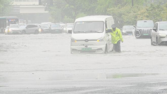 暴雨致虹桥路积水车辆抛锚 沿线交警帮忙推车